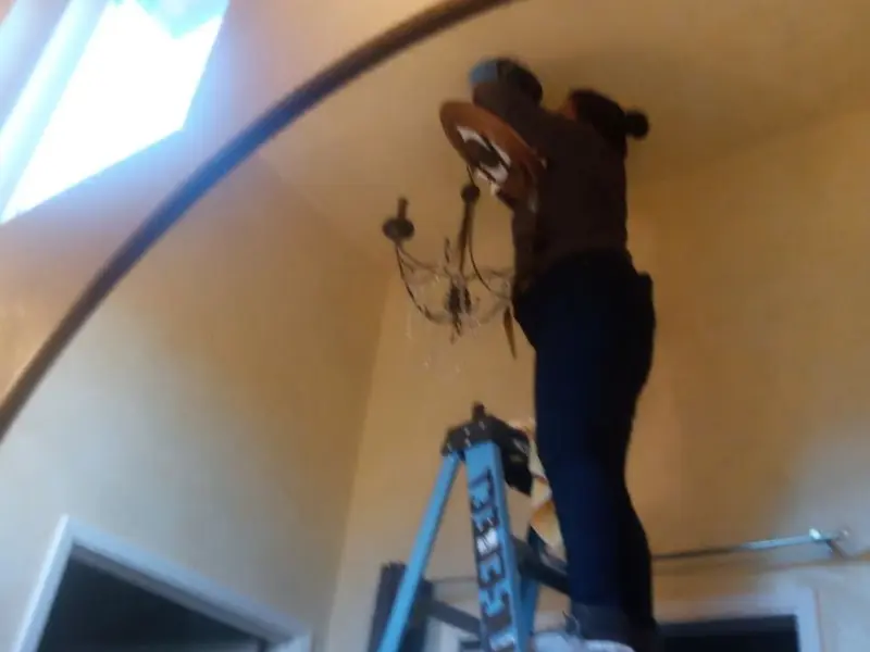 Electrician installing a chandelier in a Point Baker residence